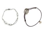 deux bracelets ornés de breloques en argent et d'un hibou en argent sur fond blanc