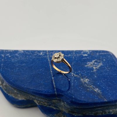 a close up of a diamond ring sitting on top of a blue stone