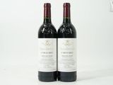 deux bouteilles de vin rouge posées l'une à côté de l'autre sur une surface blanche