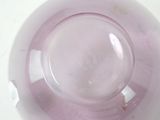 a purple glass bowl with a white lid on a table