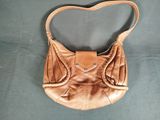 brown leather purse with a heart shaped handle on a blue background