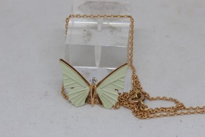 a small box with a butterfly on it on a chain
