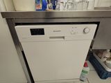 a white dishwasher sitting in a kitchen next to a sink