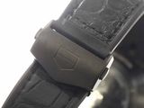 a close up of a watch with a black leather strap