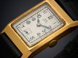 an image of a gold plated wrist watch with a black leather band