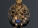 an image of a gold and silver broochle with a crown on it