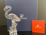 une photo d'une figurine en verre représentant un flamant rose posée sur une table