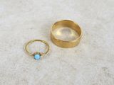 a close up of two gold rings with a turquoise stone