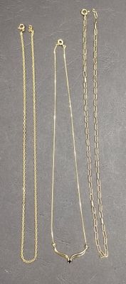 four different types of necklaces on a gray surface