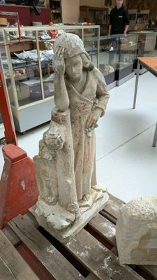 une statue représentant une femme et un mouton dans une boutique