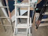 a ladder that is sitting next to a pile of wood