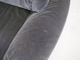 a close up of a couch with a cat laying on top of it