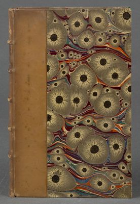 un vieux livre avec une couverture dorée ornée d'un motif
