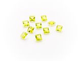 a pile of yellow glass cubes on a white surface