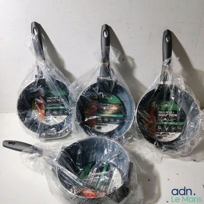 quatre poêles recouvertes d'un film plastique, posées sur un plan de travail