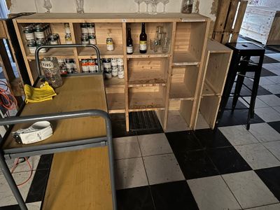 un petit bar avec un casier à bouteilles dans un coin de la pièce