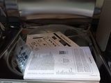 a microwave with a paper in it that is open