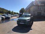 des voitures garées sur un parking devant un immeuble, avec le ciel en arrière-plan