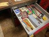 un tiroir rempli d'outils divers sur un établi