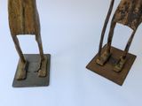 two wooden sculptures of a man and a woman on a table