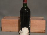 une bouteille de vin posée à côté d'une caisse en bois