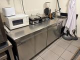 stainless steel counter top in a commercial kitchen with a microwave and toaster