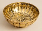 assiette dorée ornée d'un motif floral sur fond blanc