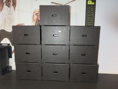 several black boxes stacked on top of each other in a room