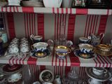 de nombreuses tasses et soucoupes posées sur une étagère dans une pièce