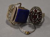 pair of silver and blue rings with garnets on a gray surface