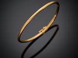 a close up of a gold bang with a single diamond in the middle