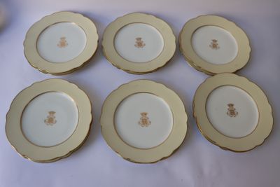 six assiettes dorées et blanches ornées d'un ours, posées sur une table