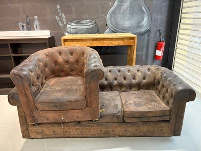 un canapé et un fauteuil dans une pièce où est accroché un tableau au mur