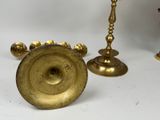 two brass candlesticks and a candle holder on a white background