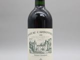 une bouteille de vin rouge posée sur une table blanche