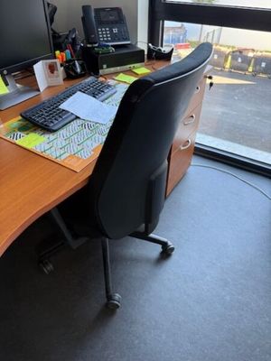 un bureau avec un ordinateur et un clavier, placé devant une fenêtre