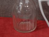 a white plate and a glass bottle sitting on a red table