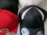 several different colored hats are lined up on a white surface