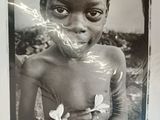 an old black and white photo of a young boy holding a flower