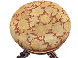 an antique foot stool with a gold and brown design on it