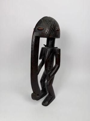 une sculpture en bois représentant un homme à la grosse tête et au long nez
