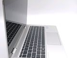 a silver laptop with a black keyboard on a white surface