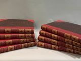several red books stacked on top of each other on a table