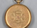 an image of a gold pocket watch with a medallion on the front
