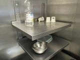 a stainless steel shelf with a bottle of water on top of it