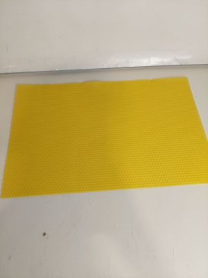 un gros plan d'un tapis jaune posé sur une surface blanche
