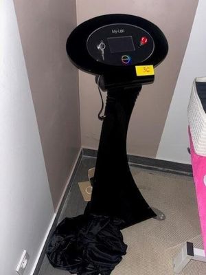 une table noire avec un plateau noir et une chaise rose
