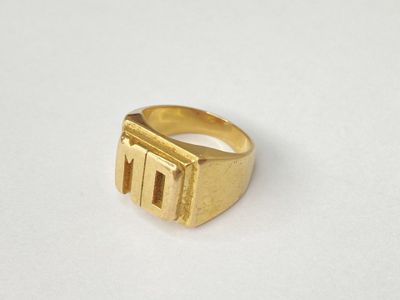 a close up of a gold ring on a white surface