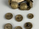 some old brass buttons and a tag on a white surface
