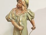 a statue of a little girl holding a dog on a leash